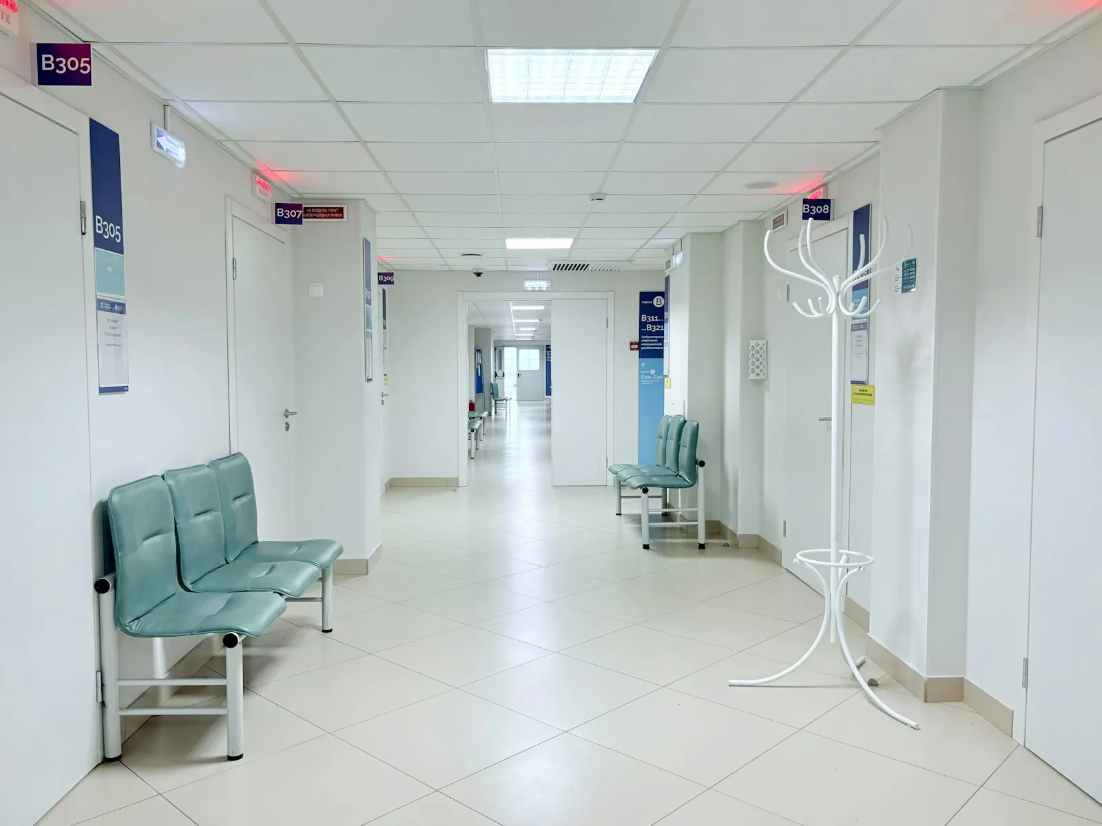 A clinical corridor with seating outside consulting rooms