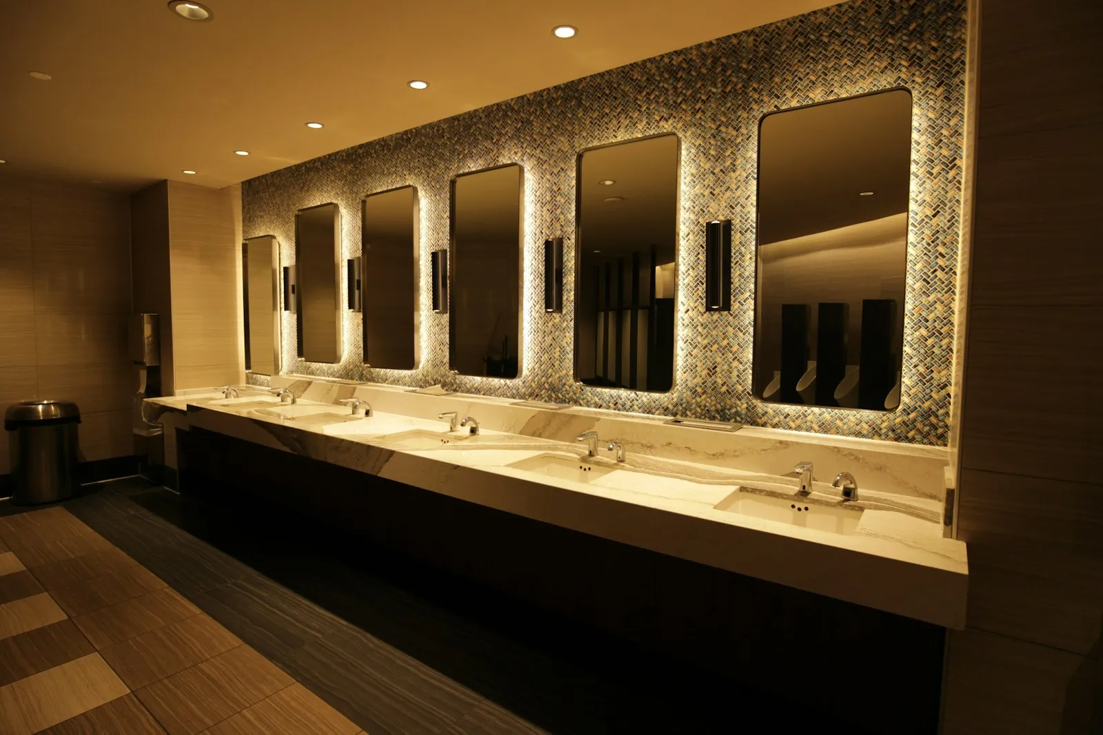 A commercial restroom with a run of sinks and mirrors